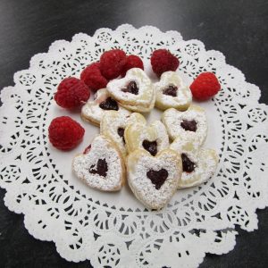 Spitzbuebe (heart-shaped shortbreads with raspberry jam) on a doilie